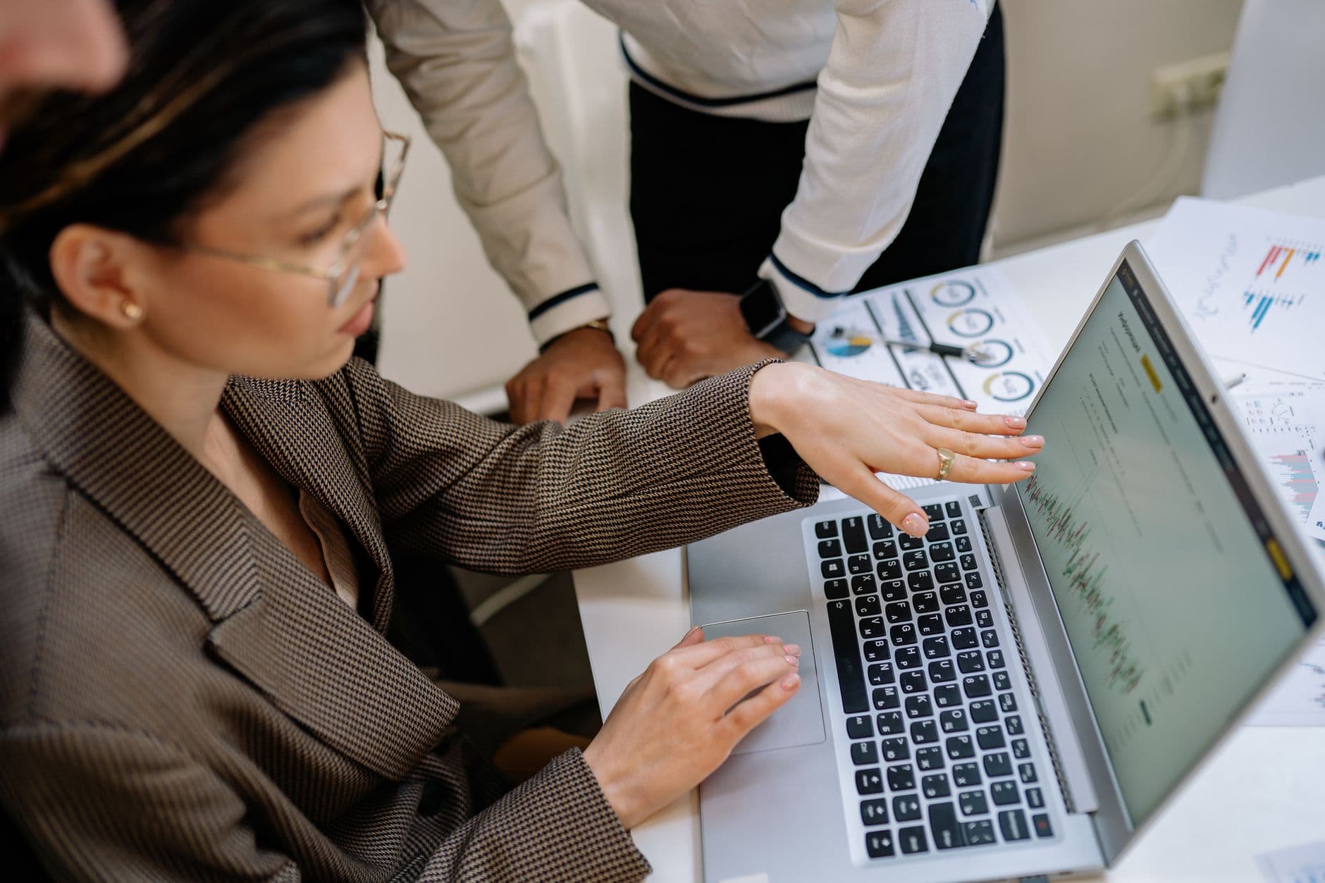 Equipo de TI señalando la pantalla de la computadora mientras discute un informe de red