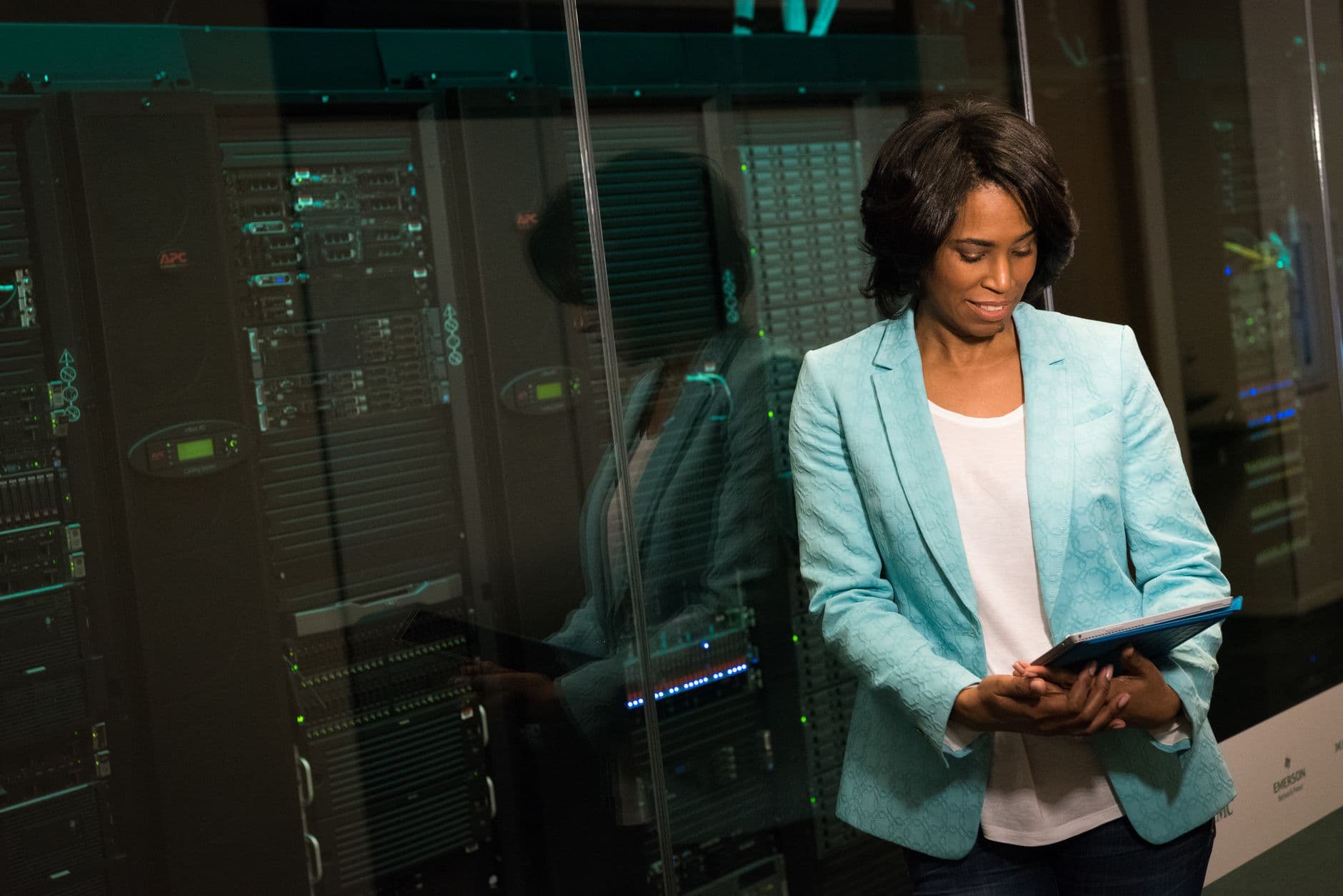 IT professional with a tablet in front of data center racks