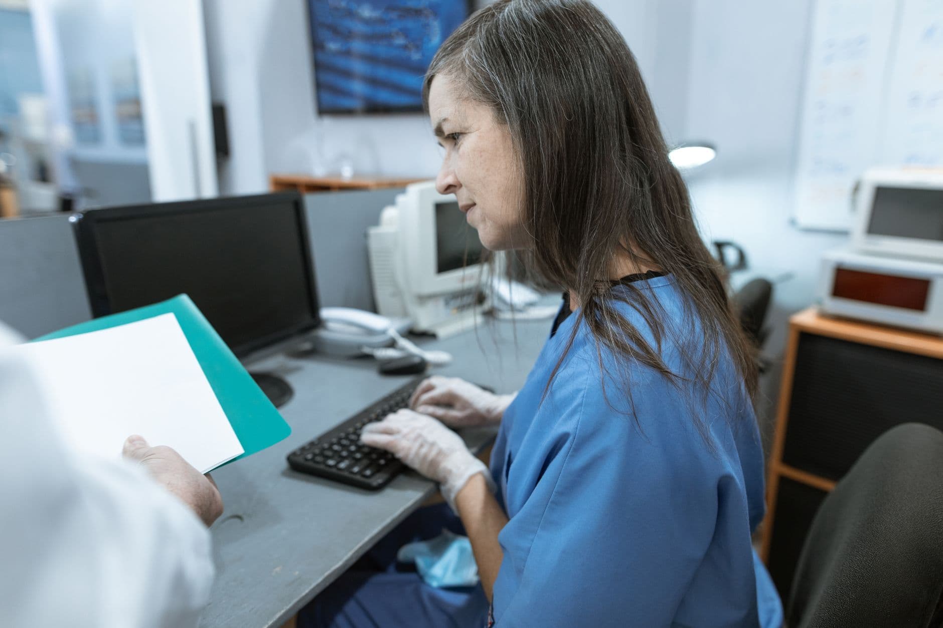 Healthcare professional checking records on a computer