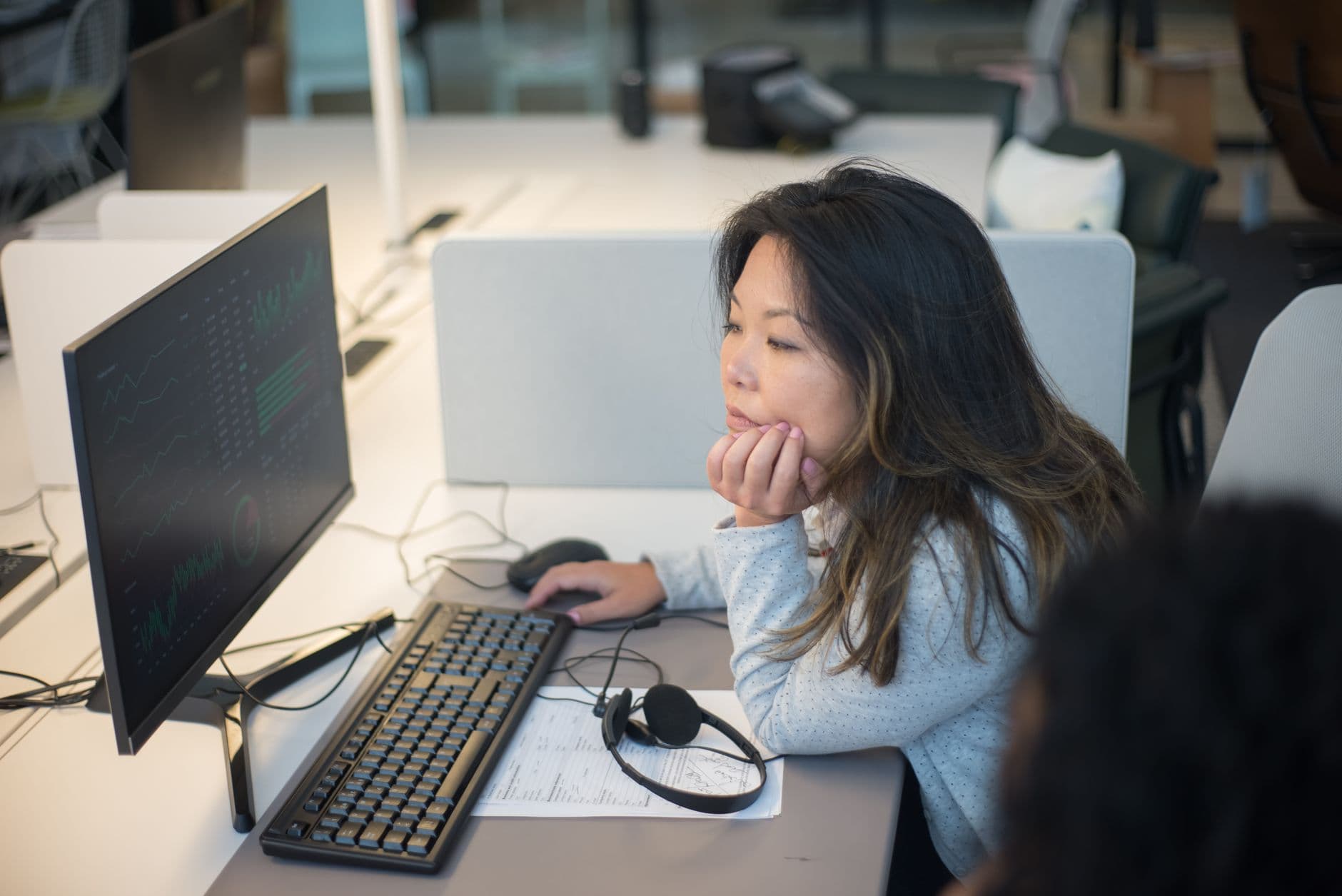 Analyst tracking data dashboards on a monitor in the office