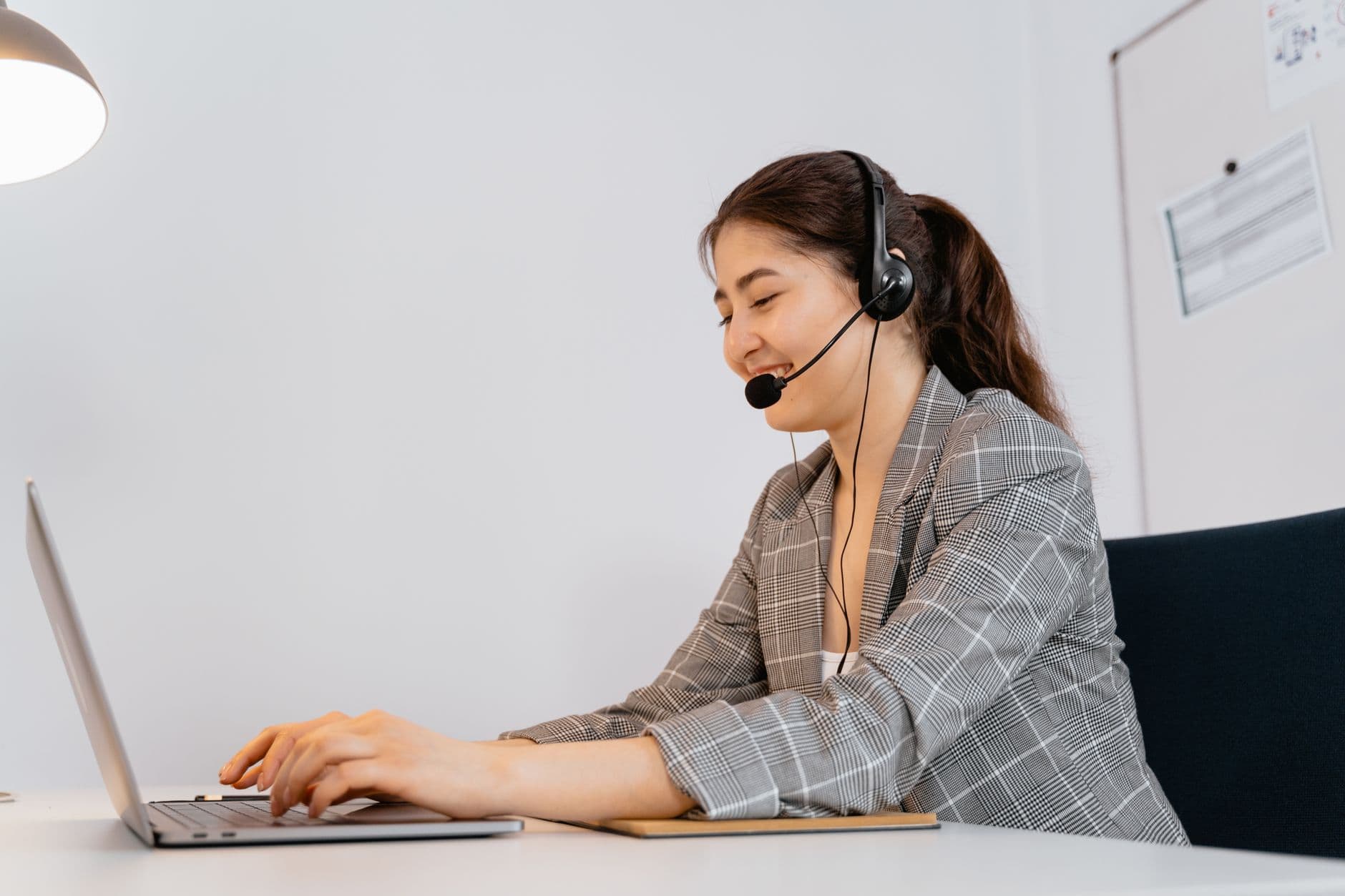 Employee taking a call with a headset while working remotely