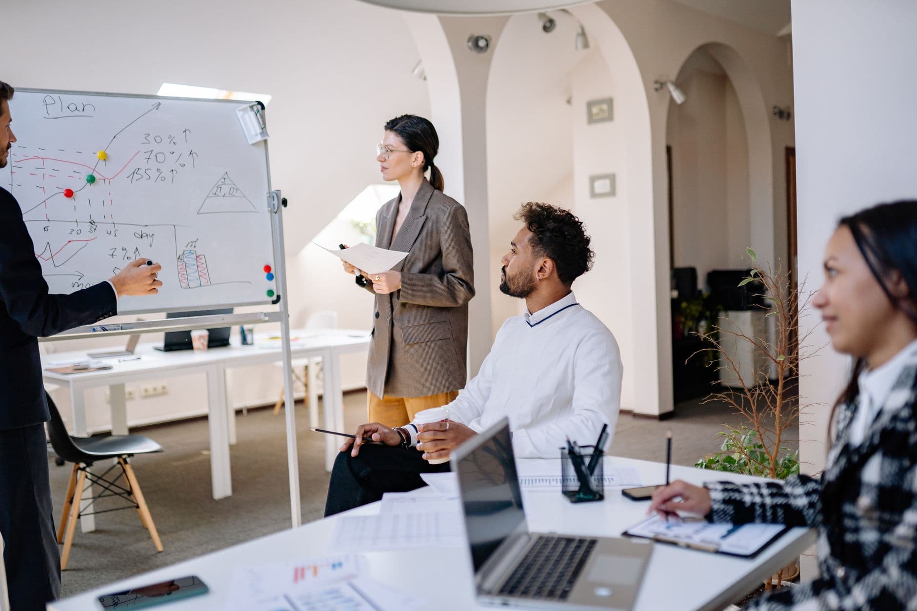 Coworkers discussing ideas in front of a whiteboard