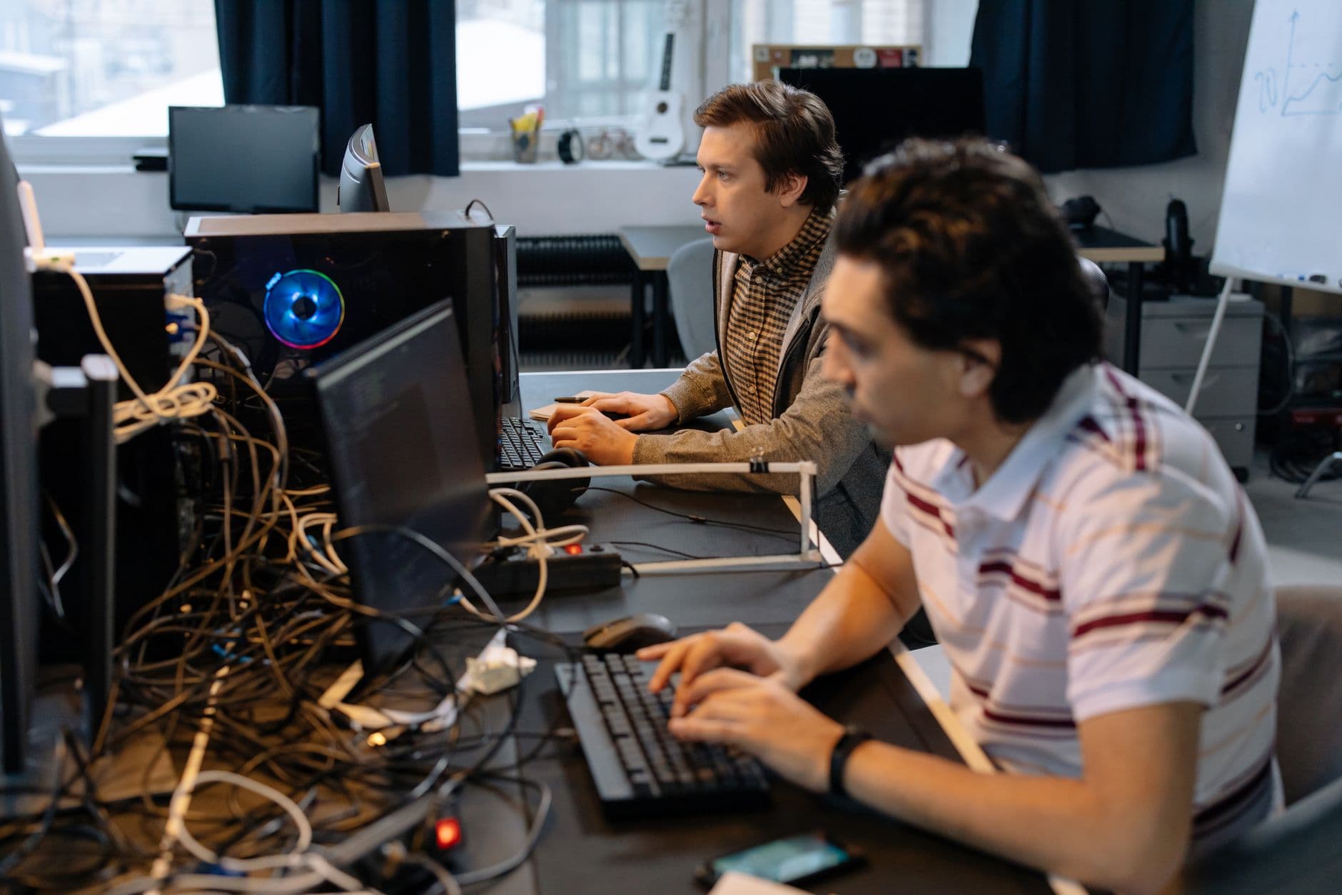 Team of IT professionals collaborating around a laptop at the office