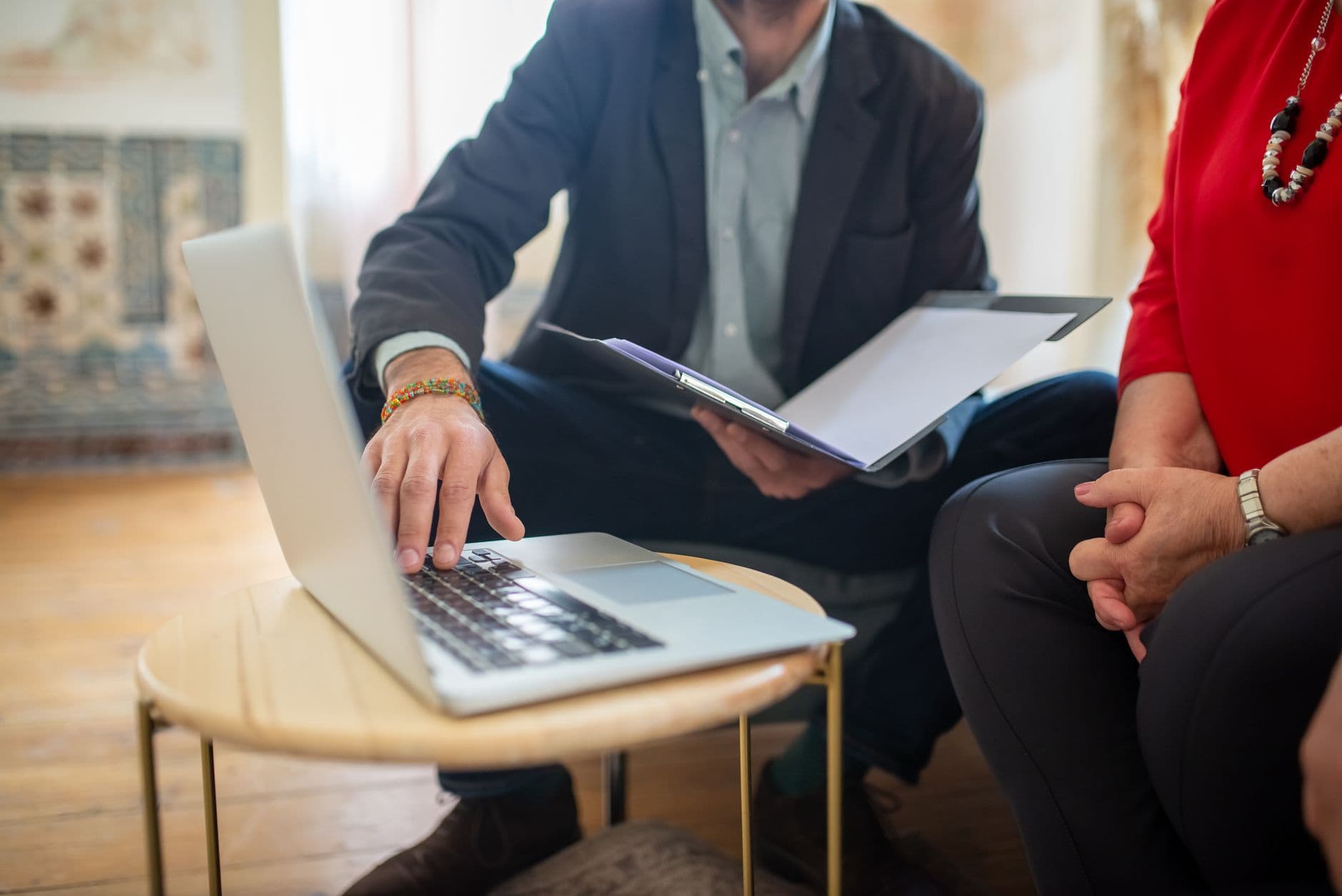 Consultant with a laptop and a document folder in a meeting with the client