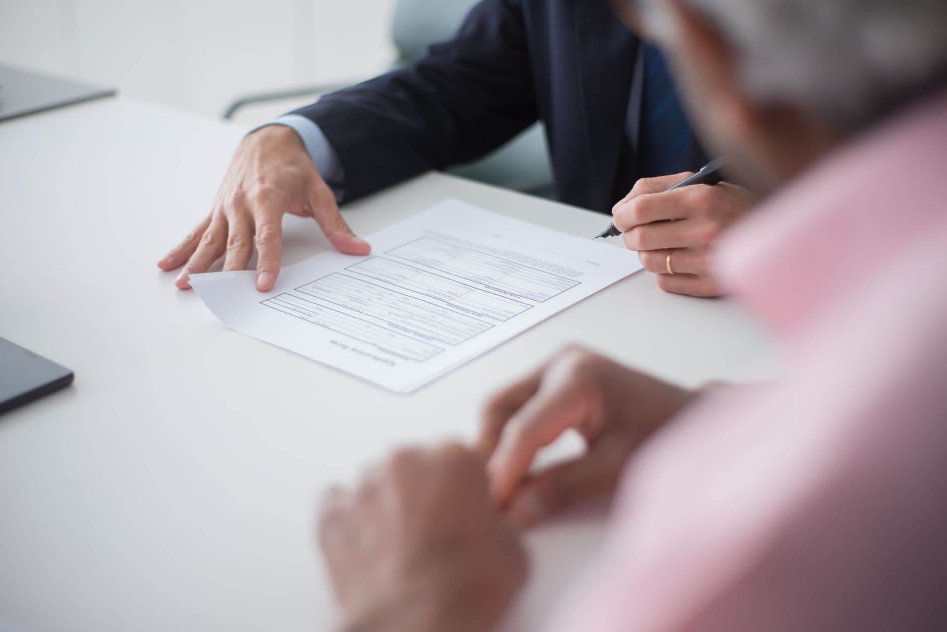 Consultor y cliente en una reunión revisando documentos de proveedores