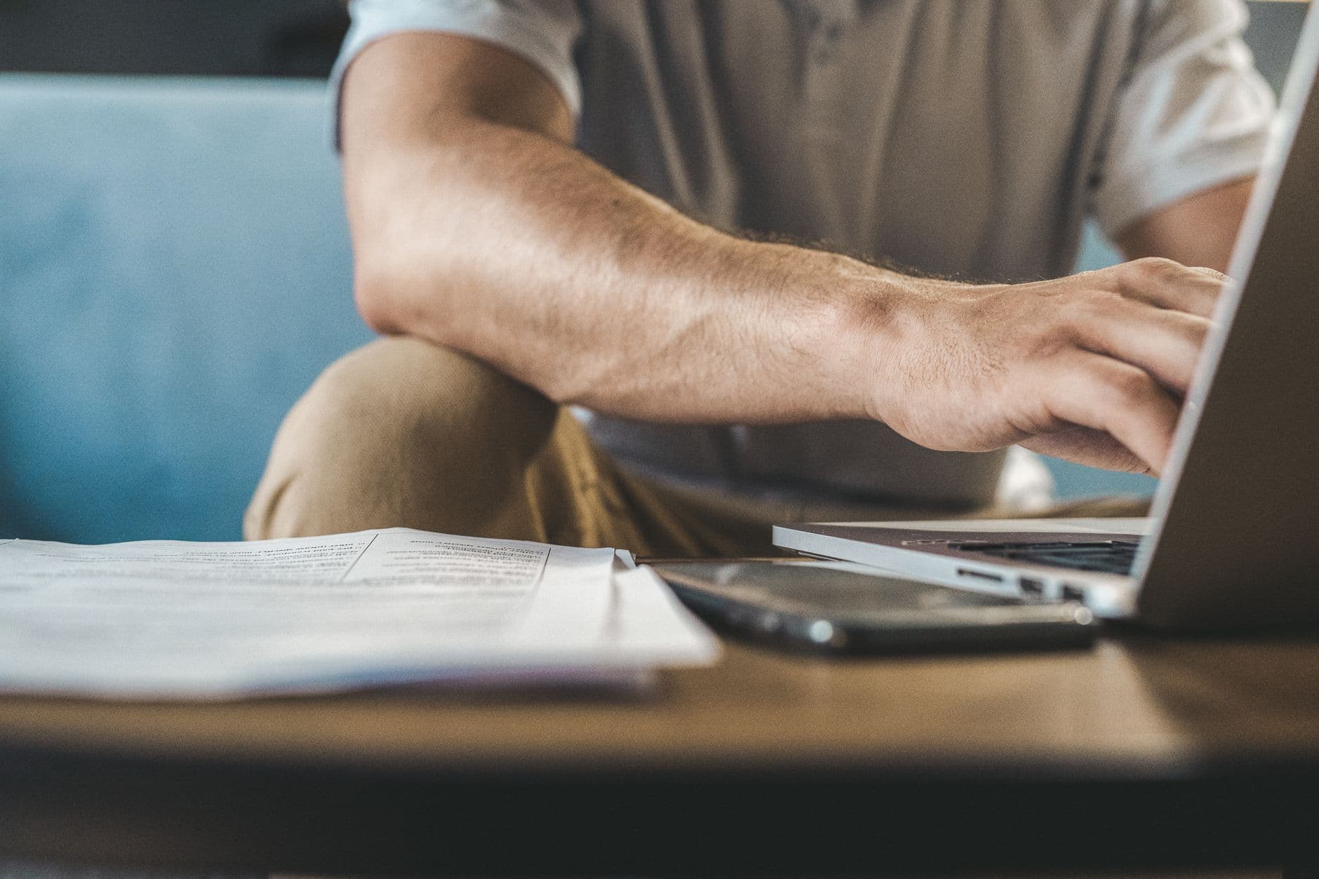 IT professional reviewing documents next to a laptop