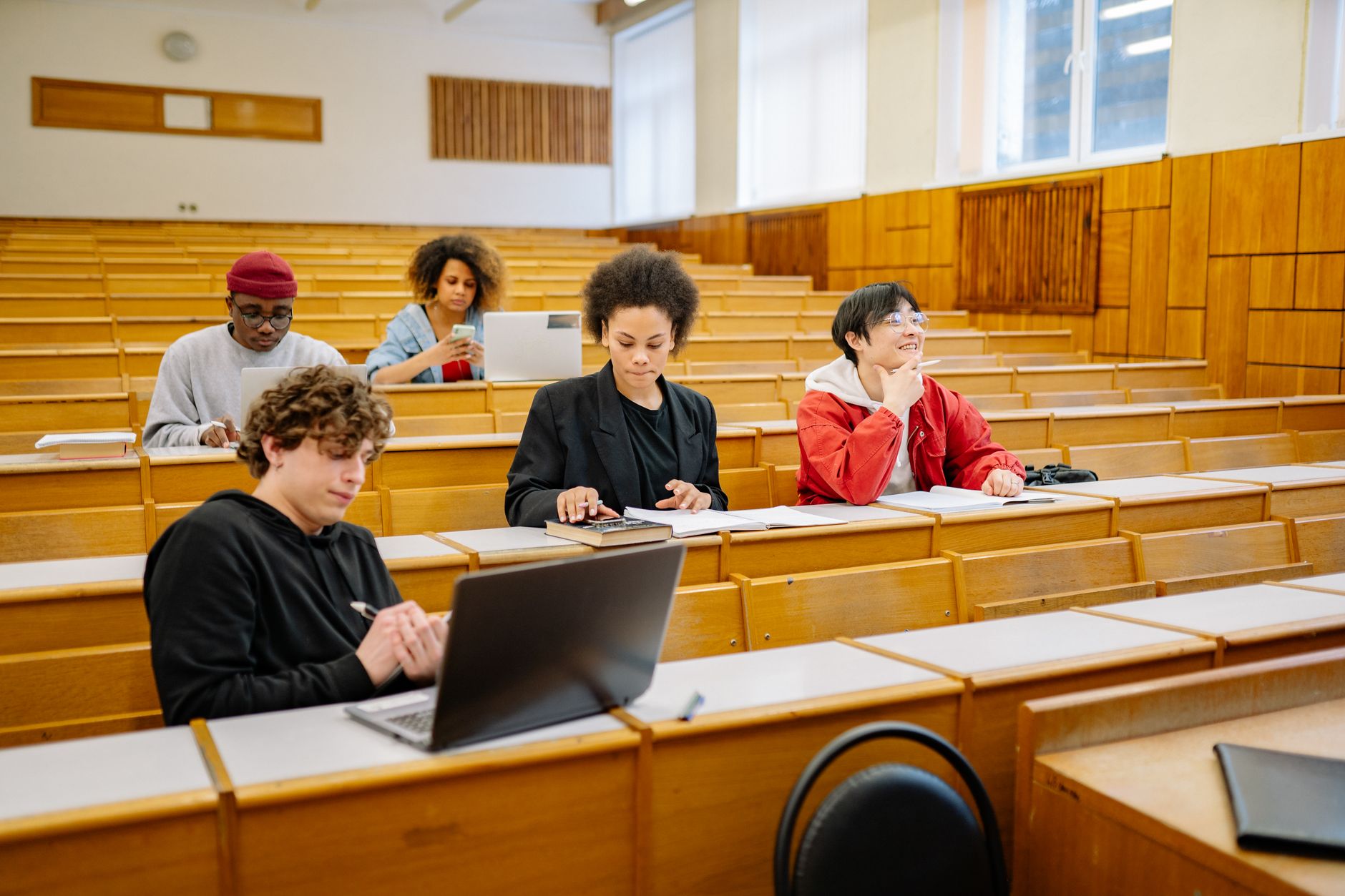 Sala de aula universitária com estudantes usando notebooks