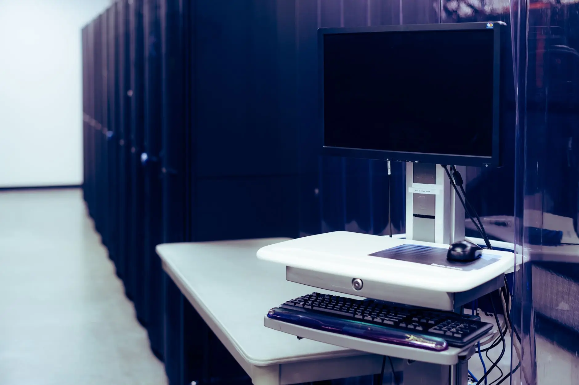 Estação de trabalho ao lado dos racks de servidores em um data center