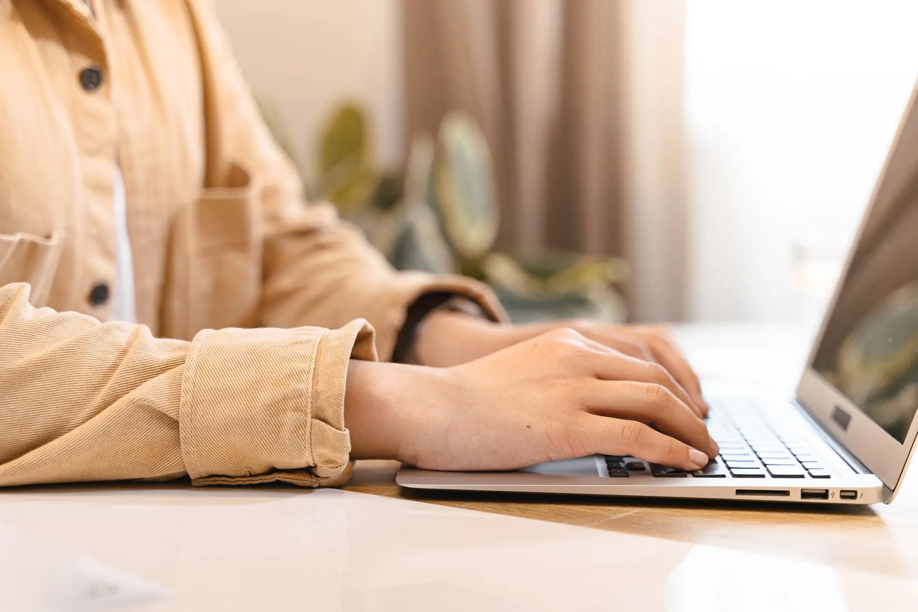 Pessoa digitando no notebook em um ambiente de escritório
