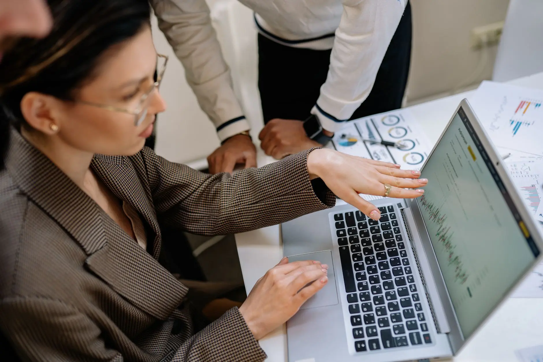 Equipe de TI apontando para a tela do computador ao discutir um relatório de rede