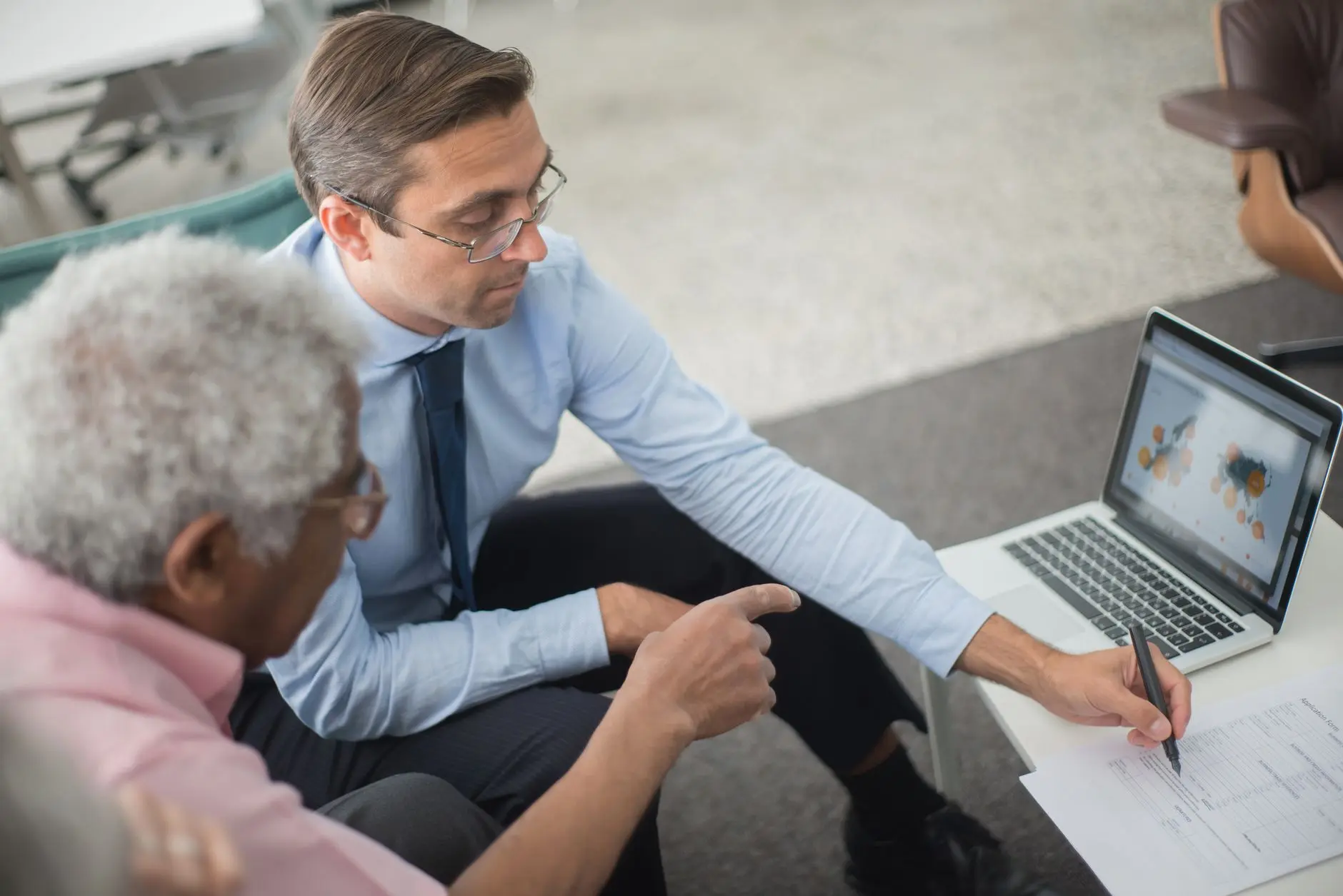 Dirigente de empresa em reunião com consultor de TI, diante de um notebook