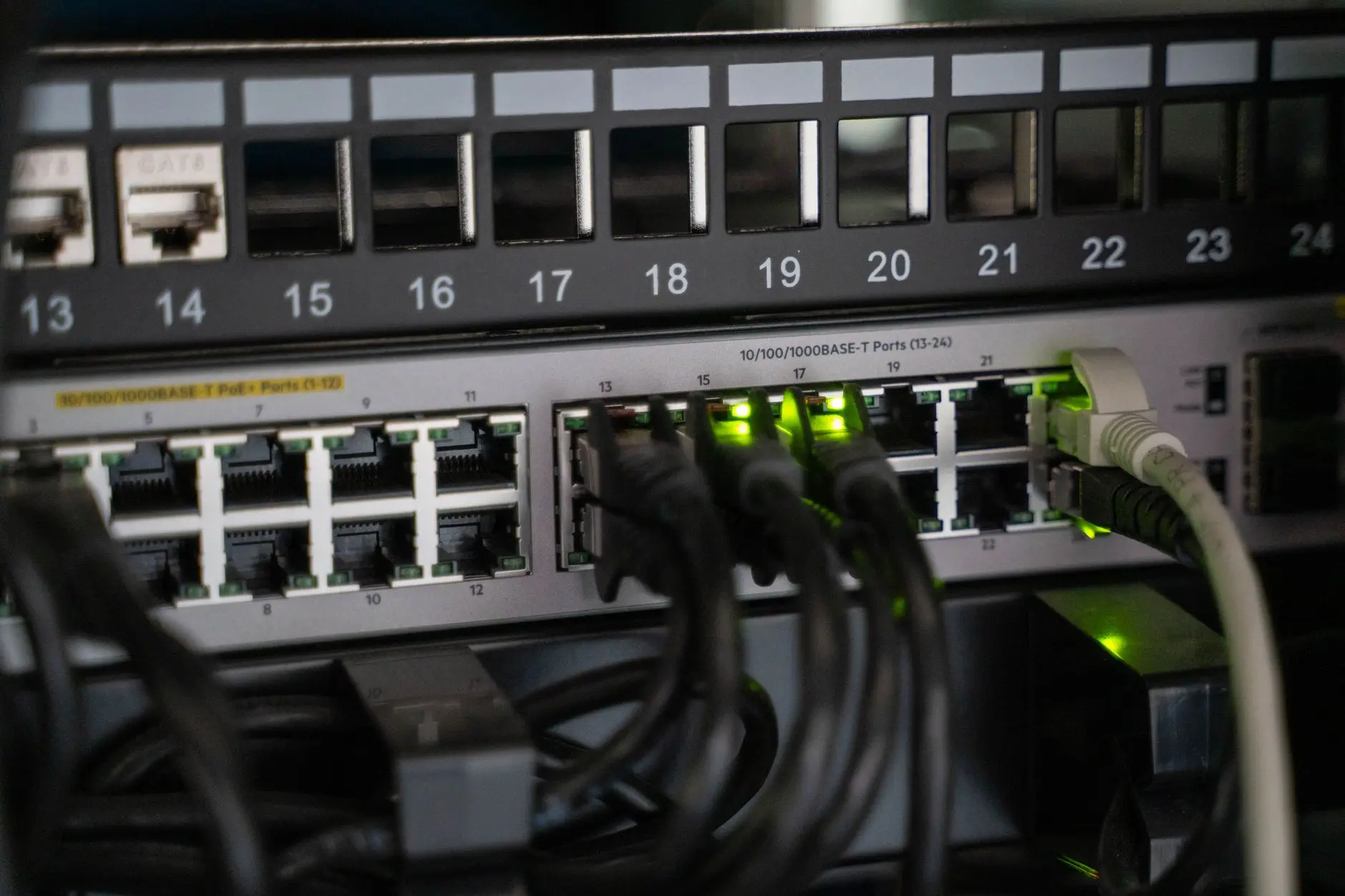 Switch de rede PoE e patch panel Cat 6 em rack, infraestrutura usada pela telefonia IP